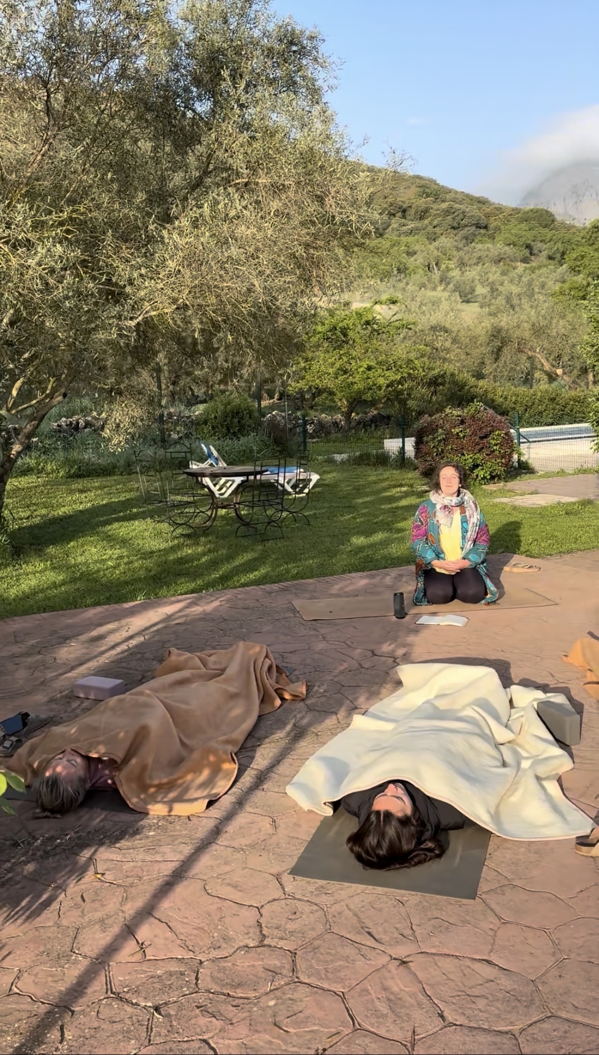 Miriam guiding participants through outdoor Savasana